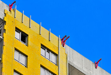 Fragment of the upper part of the facade of a residential building under construction on an autumn...