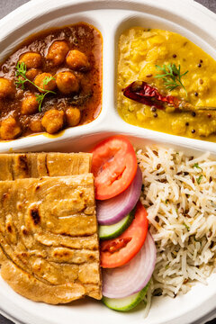 Indian mini meal parcel platter, combo thali with chole Masala, roti, dal tarka, jeera rice, salad