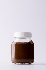Vertical image of jar of chocolate cream on white background