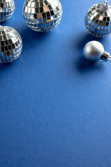 Composition of close up of new years baubles on blue background