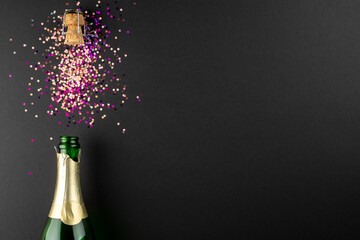 Composition of close up of new years champagne with confetti on black background