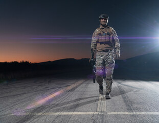 Army soldier in Combat Uniforms with an assault rifle, plate carrier and combat helmet going on a...