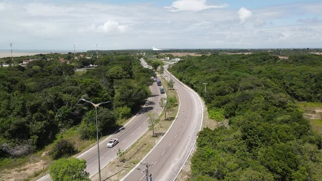 DRONE PERCORRENDO A ESTRADA QUE VAI PARA ESTA&Ccedil;&Atilde;O CIENCIAS COM CARROS PASSANDO NA ESTRADA E MUITO VERDE (Drone flying along the road to the Science Station with cars passing by and lots of greenery.)