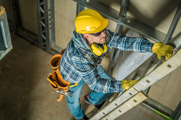 Construction Worker Using Extension Ladder - obrazy, fototapety, plakaty