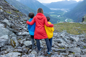 Family with children and dog, hiking in Litlefjellet on sunset, enjoying amazing view from the top of hiking trail