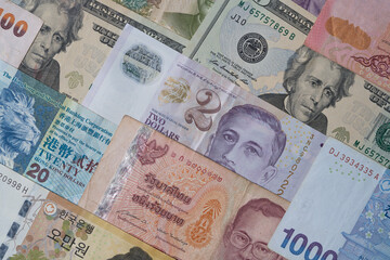 Obraz premium Closeup of variety banknote around the world include dollar Yuan Baht Peso Won for currency exchange or Forex investment and money payment transfer concept.
