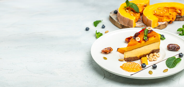 pumpkin cheesecake, slices of pumpkin cheesecake with nuts on a light background. Long banner format. top view