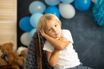 Cute preschool boy, playing with airplane, balloons and birthday decoration