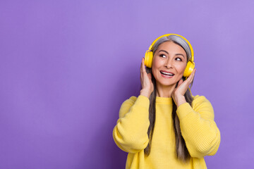 Photo of pretty dreamy lady pensioner dressed pullover arms headphones looking empty space isolated...
