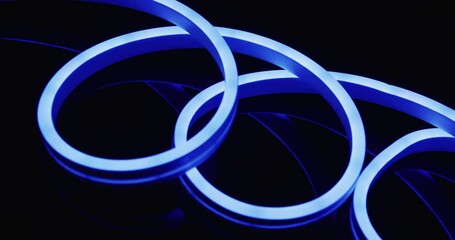 Animation of blue neon lights forming spiral over black background