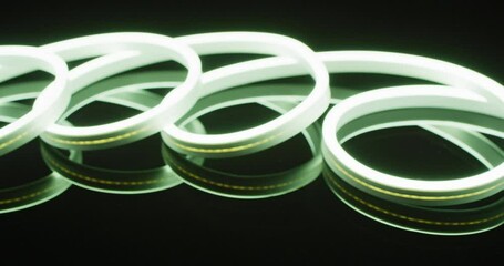Animation of white neon lights forming spiral over black background