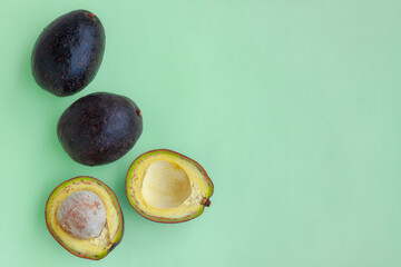 Avocado fruit with cut in half on green background, Healthy fruit