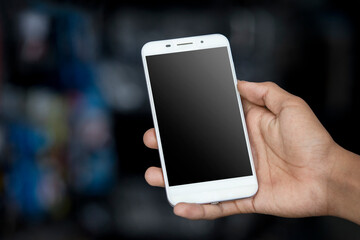 Close up, man hands holding smart phone with blank copy space screen for your text message on dark and blurry background