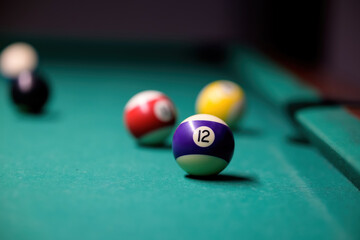 Many multicolored billiard balls on a green table. Set of balls.