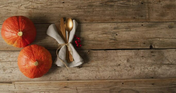 Video of cutlery and pumpkins lying on wooden surface