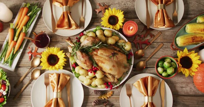 Video of tray with roasted turkey, diverse dishes and autumn decoration on wooden surface