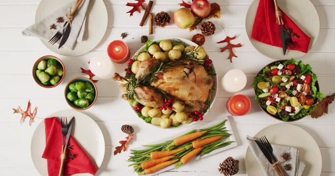 Video of tray with roasted turkey, diverse dishes and autumn decoration on white surface