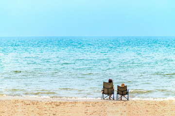 woman sitting on green chair on beach with sea background, Thailand.