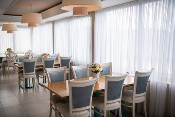 Elegant luxury interior in white colors. Beautiful vintage decoration for wedding, birthday, party or restaurant table set. Decoration with flowers in vase. Natural light.