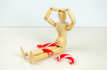 man bent over broken Candy cane in despair. Preparation for Christmas, stress, frustration, failure