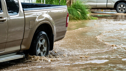 Pickup truck passing through flooded road. Driving car on flooded road during flood caused by...