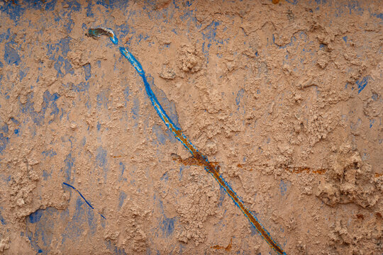 Dried roughly clay or mud on metal chemical waste containment storage tank's surface. Close-up photo.