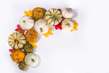 Autumn decorative pumpkins with fall leaves on white table background. Fall Thanksgiving halloween holiday greeting card background, harvest concept. Top view, copy space