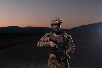 Army soldier in Combat Uniforms with an assault rifle, plate carrier and combat helmet going on a...