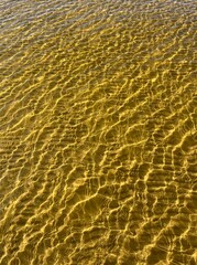 Transparent sea water ripples, sandy bottom, natural background
