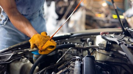 Fototapeta premium Closeup hand and spanner. Auto car mechanic checking the oil level of the car engine.