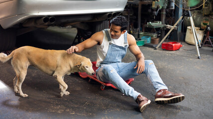 Portrait sexy model asian male mechanic engineering with big muscle and dog in a Car Service....