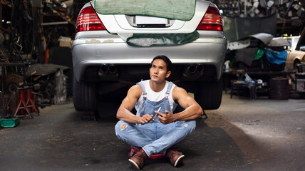 Portrait sexy model asian male mechanic engineering with big muscle in a Car Service. Repair...