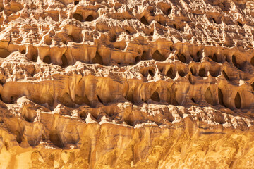 Texture and pattern of rocks in White Canyon in Sinai. Yellow and orange sandstone textured carved mountain, bright blue sky. Egyptian desert landscape. Background. Sinai peninsula, Egypt