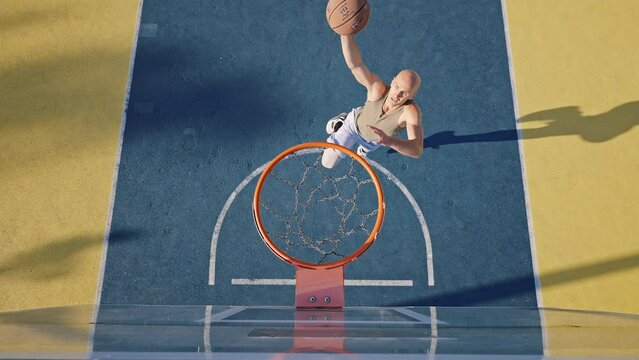 Active man runs jumping up high to throw ball into basket