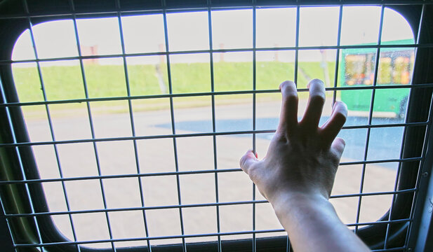 Man in prison hand holding a steel cage prison bars. criminal criminal is locked in prison.