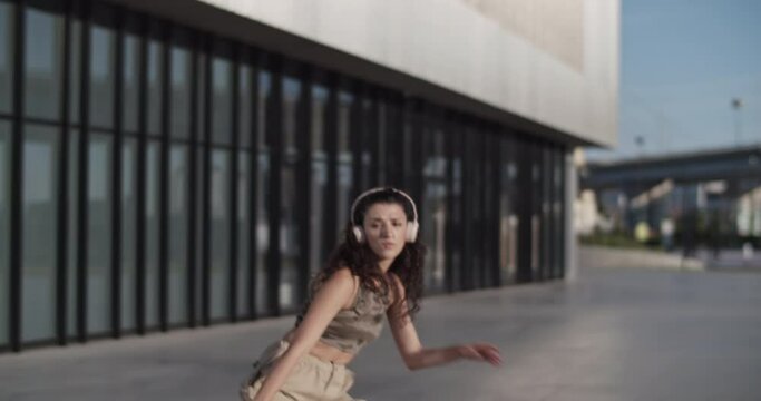 Energetic woman dancing outside contemporary building