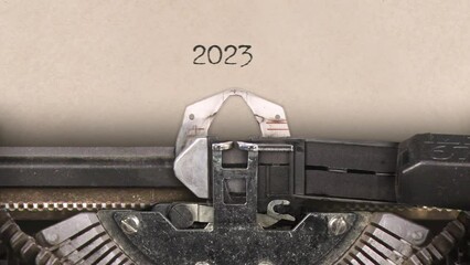 Old retro typewriter with sheet of paper. Close up. Writing year number 2023. With machine sounds. 29,97 fps