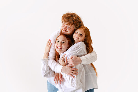 Portrait of happy family, redhaired parents and kid in casual wear look at camera with smile, have good family relationship.