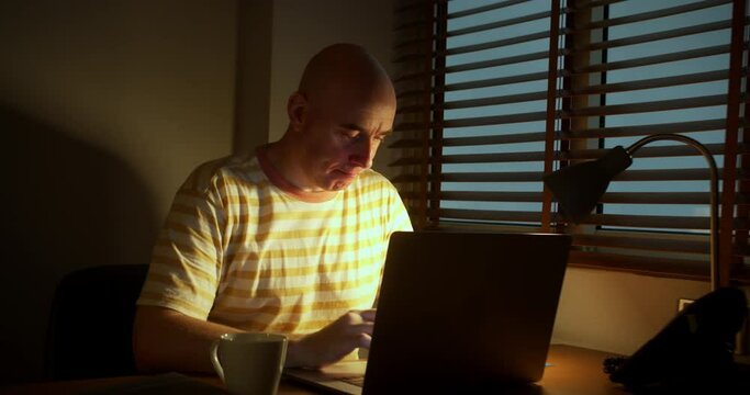 Male in work office workin on laptop abd drinking coffee. Man office employee working computer overtime works on Internet, Businessman working on laptop.