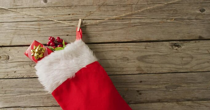 Video of christmas decoration with christmas stocking and copy space on wooden background