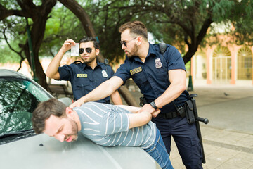 Good police officers arresting a drug dealer in the street - obrazy, fototapety, plakaty