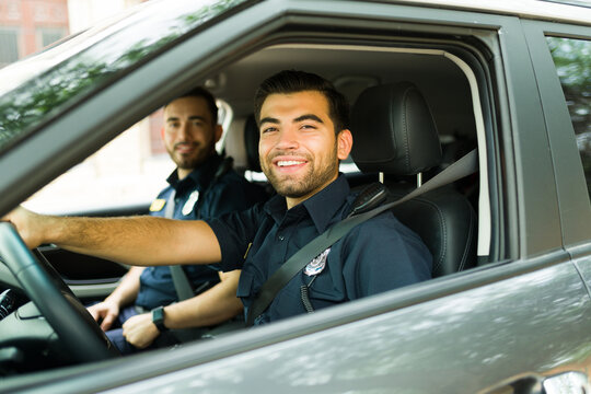 Cheerful Police Officer On Duty Driving The Patrol Car