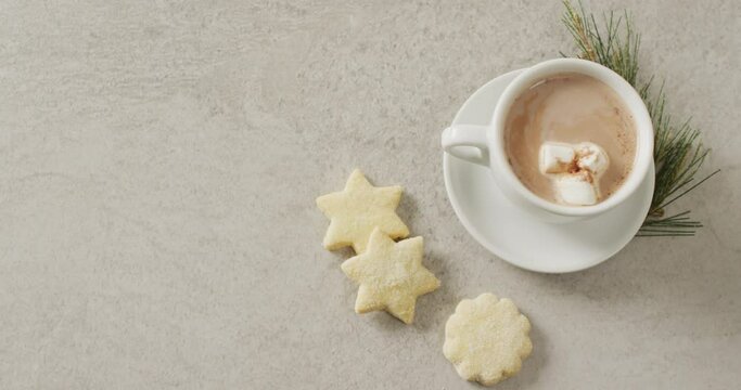 Video of cup of hot chocolate with marshmallows and biscuits over grey background