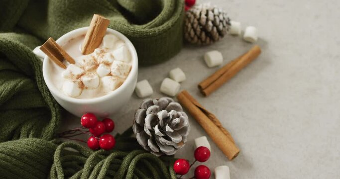Video of cup of hot chocolate with marshmallows and warm blanket over grey background
