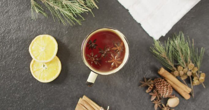 Video of cup of hot tea with cinnamon and lemon over grey background