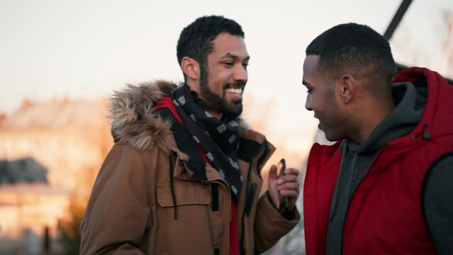 Two young men meeting outdoors.