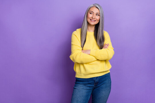 Photo of charming dreamy retired woman wear sweater arms crossed looking empty space isolated violet color background