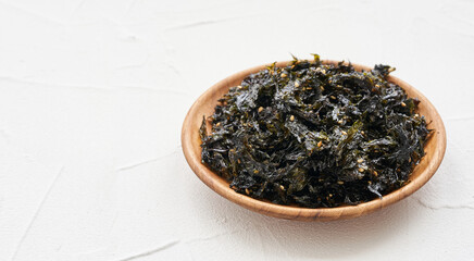 roasted nori seaweed and sesame topping in wood plate on white background. Gim, laver, nori                                              © boommaval