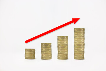 Stacked coins on a white isolated background with a red arrow. Growth investment concept