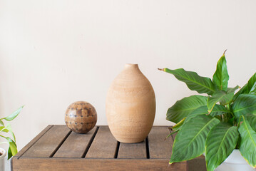 Objetos de decoración de terracota y madera, planta de interior. Esfera y ánfora.